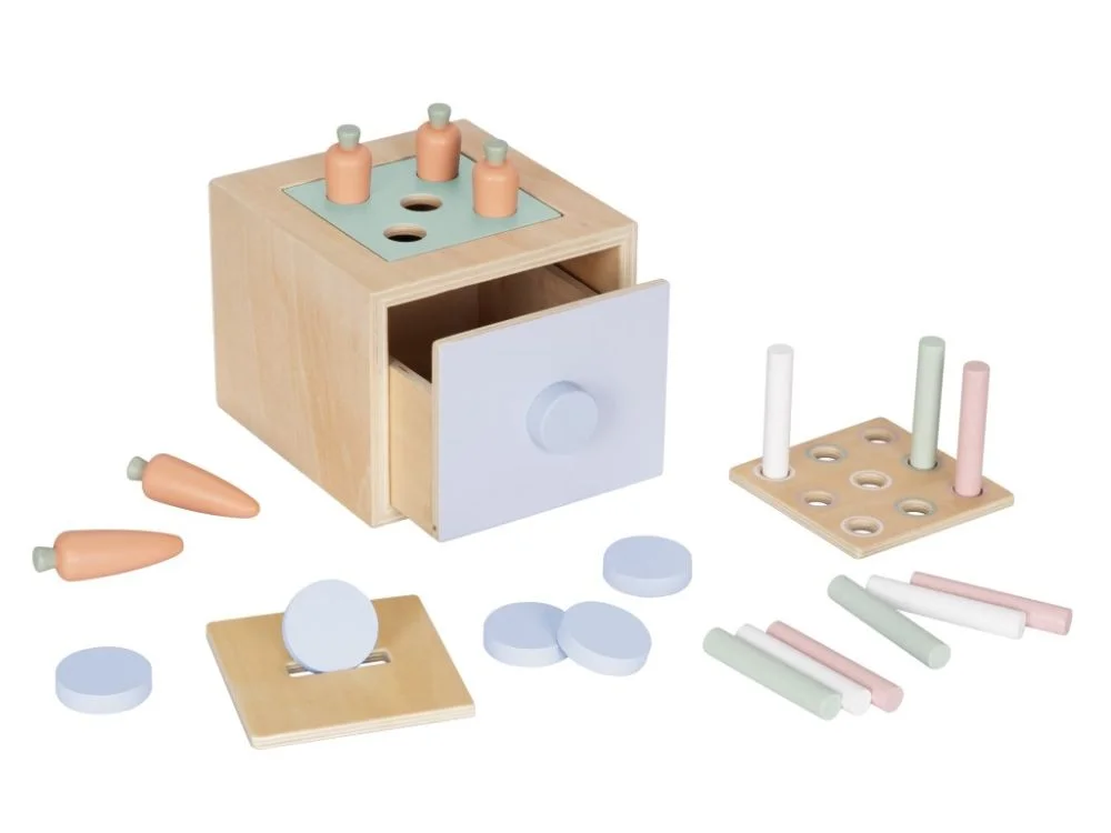 Lavinamoji dėžutė su atidarytu stalčiumi, morkytėmis, spalvotais cilindrais ir melsvais diskeliais