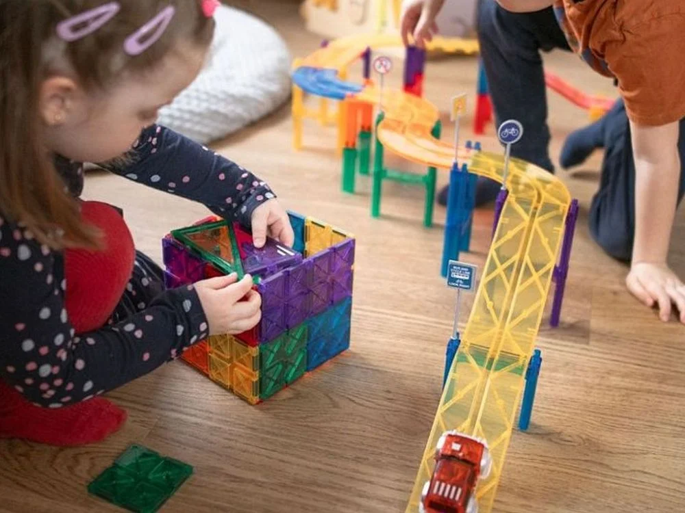 Mergaitė stato namelį iš kvadratų prie trasos